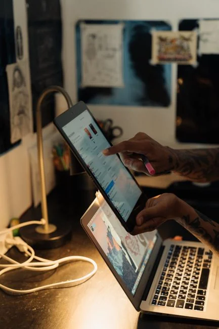 Dual monitors on a desk, showcasing web design in a modern office setting.